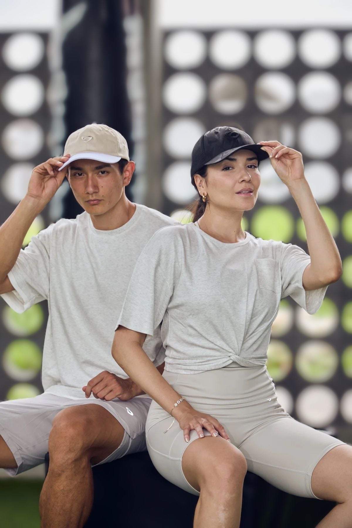 Male model wearing Duo Sand cap and female model wearing black camo cap